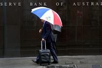 Two men walk past the Reserve Bank of Australia
