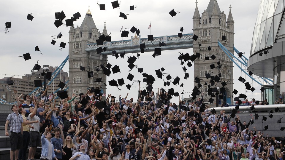 Students toss graduation caps in the air in front of London's Tower Bridge.