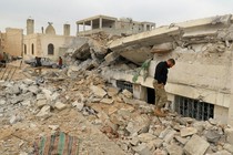 People inspect a damaged mosque after an airstrike was conducted on the rebel-held village of al-Jinah in Aleppo, Syria, on March 17, 2017. 