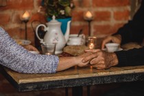 Two hands holding each other on a table