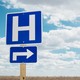Hospital road sign in an open field.