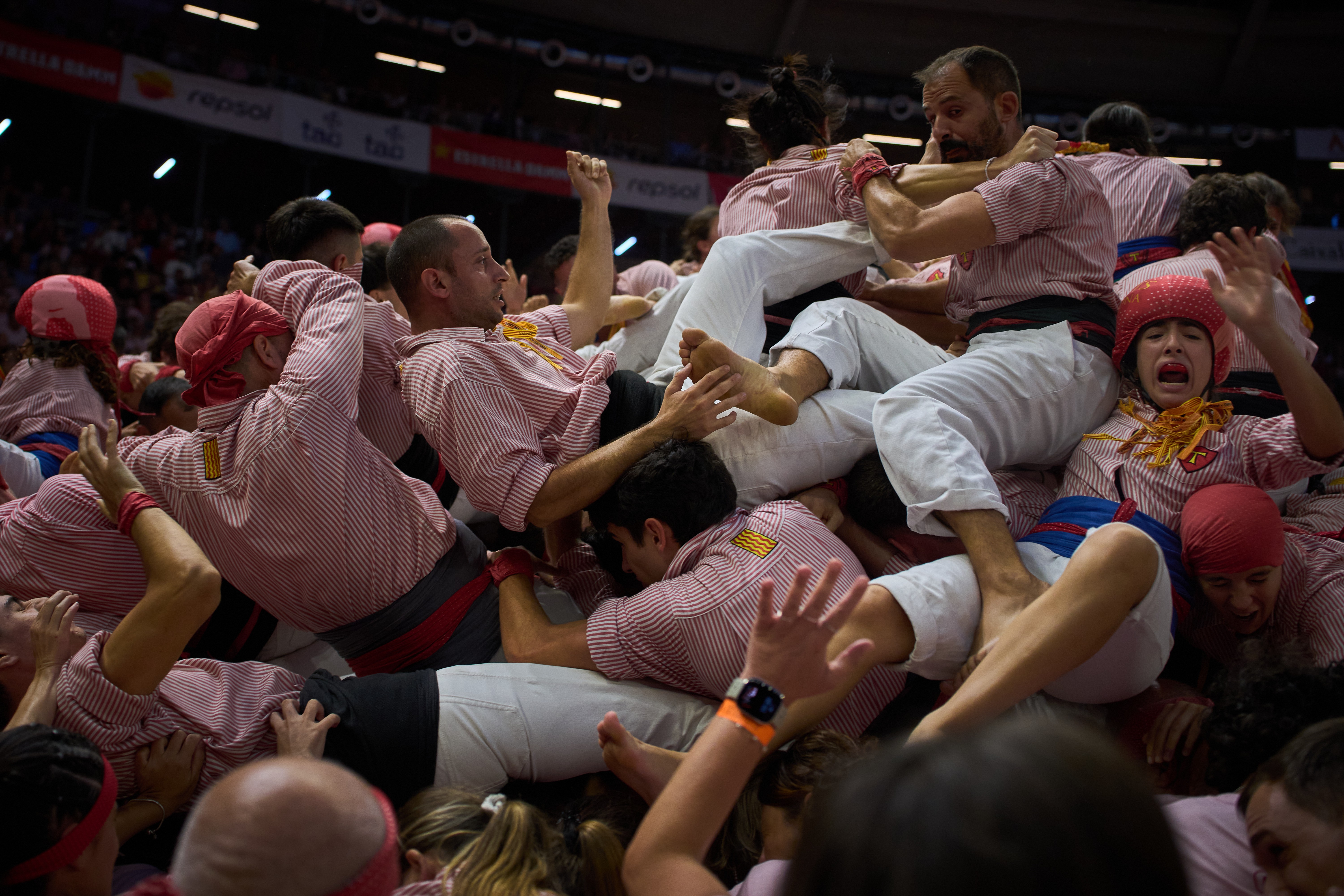 People fall after trying to form a human tower.