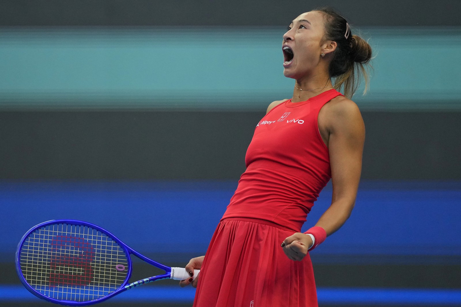 A tennis player yells in celebration.