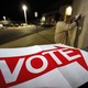 An election official hangs "Vote" signs outside a polling station in Phoenix, Arizona.