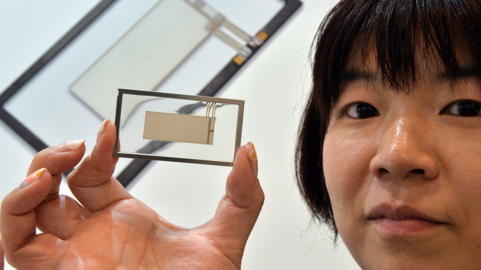 A woman holds a small, thin piezoelectric speaker