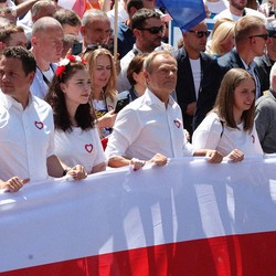 Peaceful protesters holding a big Polish flag