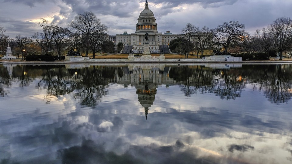 The Capitol is reflected in a pool in front of the building.