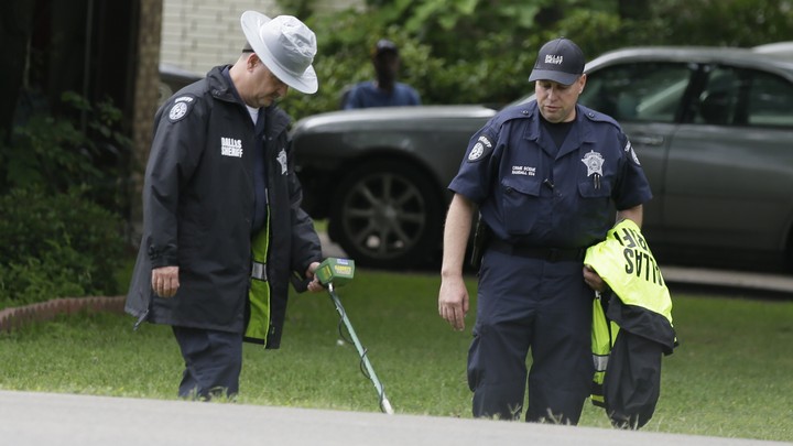 Dallas County Sheriff officials use a metal detector at the intersection near where a police officer killed 15-year-old Jordan Edwards in Balch Springs, Texas, on May 3, 2017.