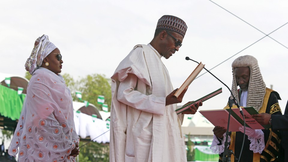 Chief Justice of Nigeria Mahmud Mohammed swears in Muhammadu Buhari (C) as Nigeria's president while Buhari's wife Aisha looks on at Eagle Square in Abuja, Nigeria May 29, 2015.