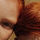 Two children with the same red hair color touching heads