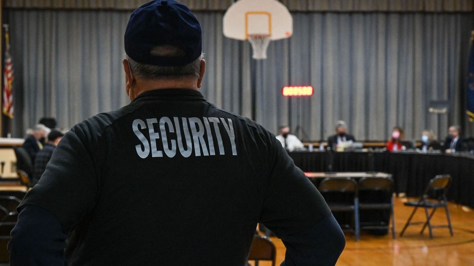 A Pennsbury School District security guard observes a Pennsbury School Board meeting