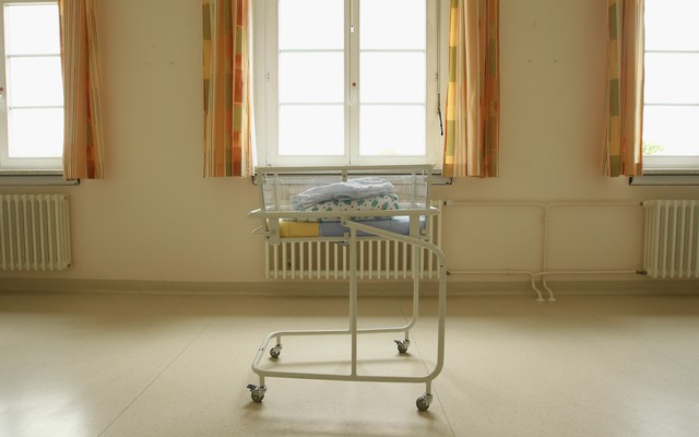 Folded blankets sit atop a cart for newborn babies.