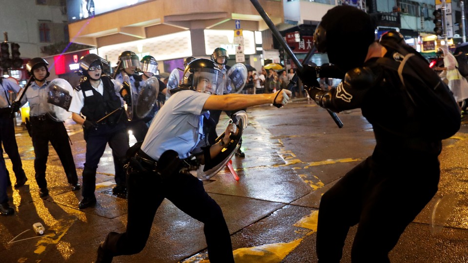 A police officer strikes a Hong Kong protester with a baton.