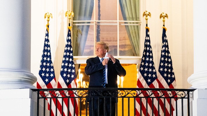 Trump on balcony taking off his mask