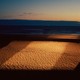 A square of light over sand on the sea