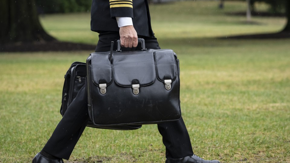 A military aide carries the "nuclear football," which contains launch codes for nuclear weapons