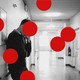 Photo of a person in a hospital hallway, overlaid with large red dots