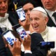 Pope Francis arrives to lead his weekly general audience in 2016 at the Vatican as people take pictures of him.