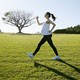 A pregnant woman exercising in a field