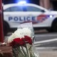 Flowers at a memorial in front of a police car