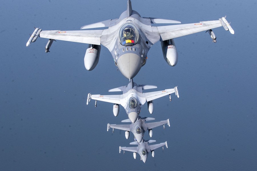 Four military fighter jets fly in a line.