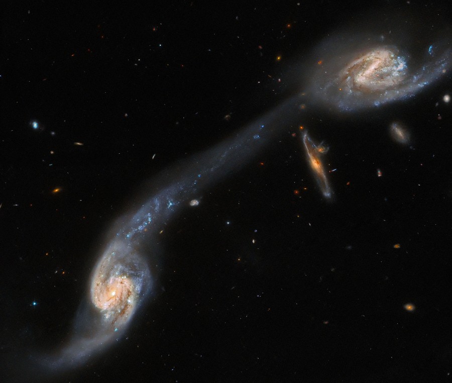 Two galaxies are seen somewhat close together, with a long 'bridge' of stars seen between them.