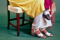 An image of a mother in high heels holding her son