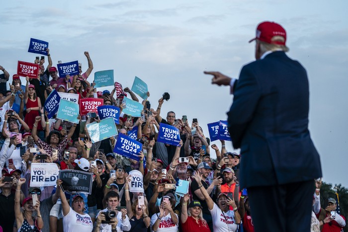 Donald Trump points to a crowd of supporters at a rally