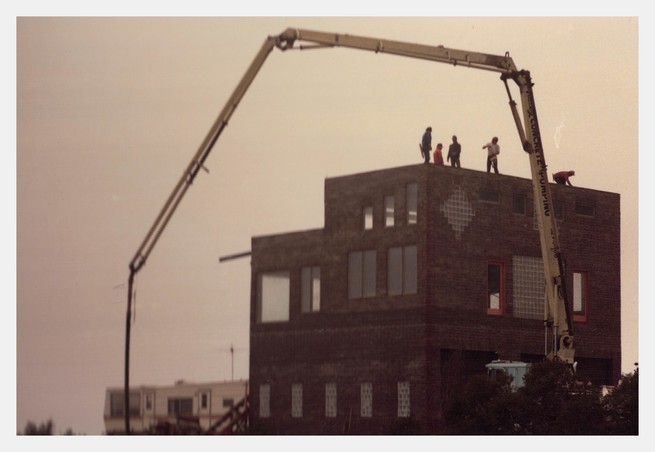 People stand on a roof as it's being built