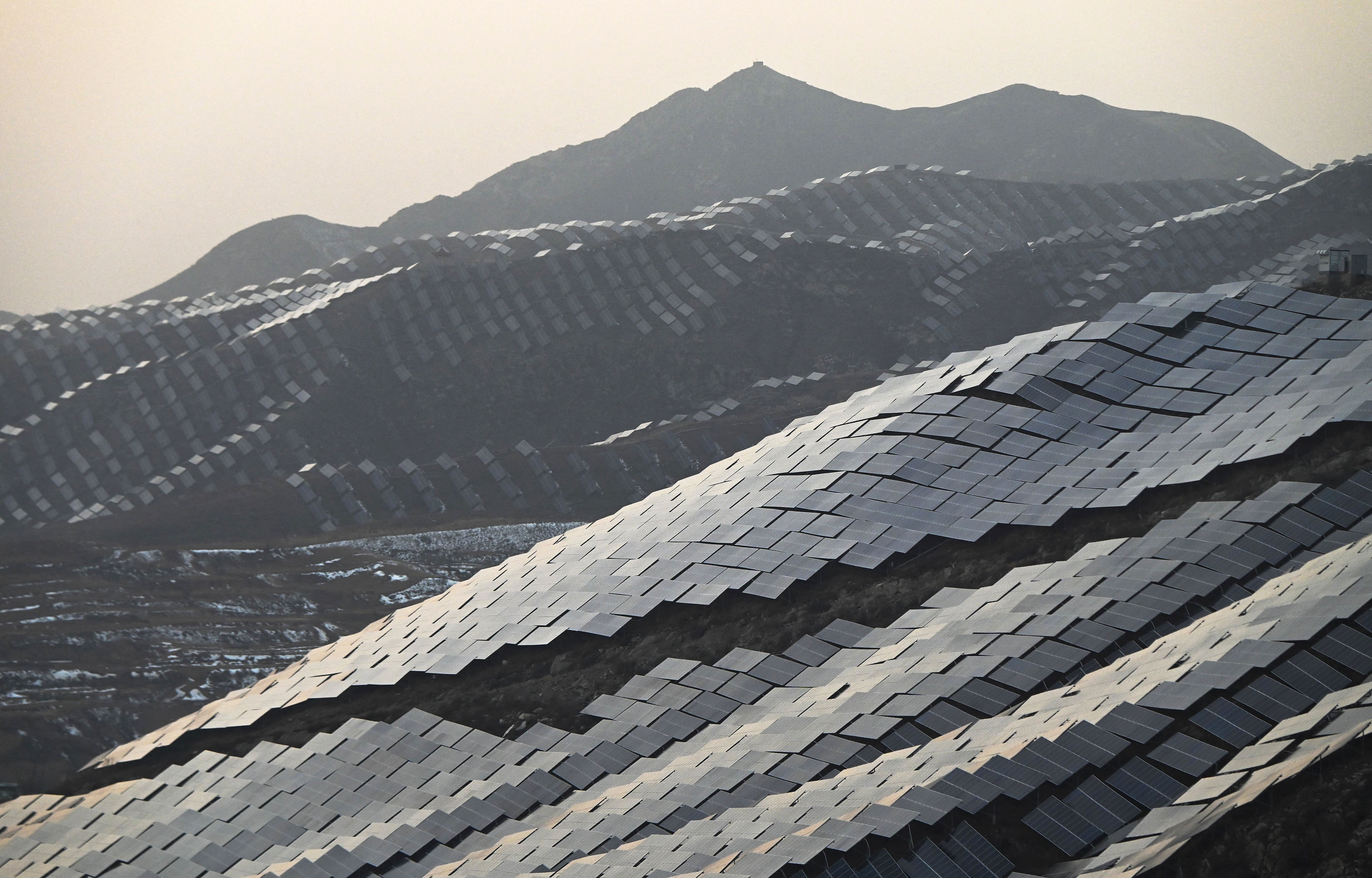 An aerial view of solar panels covering several hillsides.