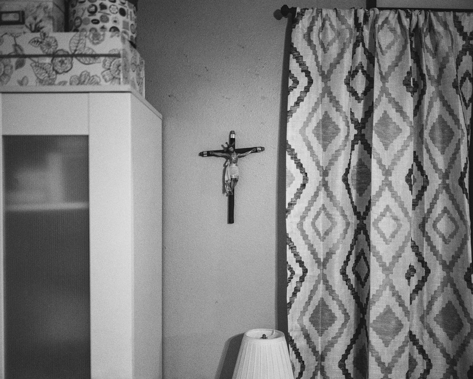 A cross hangs above Jose Ulloa’s bed in Wilmington, Calif. Ulloa struggles with severe asthma and a lingering cough. Pablo Unzueta/ Magnum Foundation