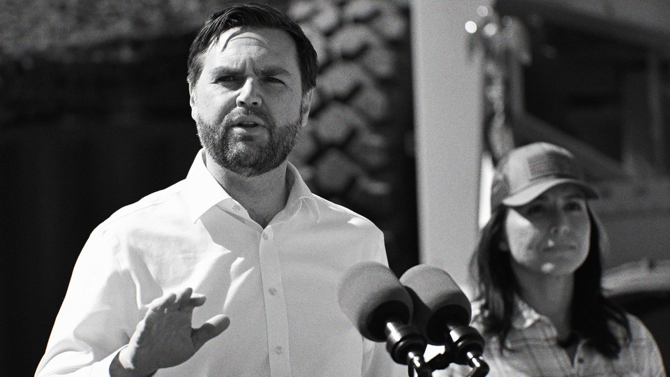 Head-on black-and-white photo of J. D. Vance speaking at a podium, with Tulsi Gabbard standing a few feet behind him