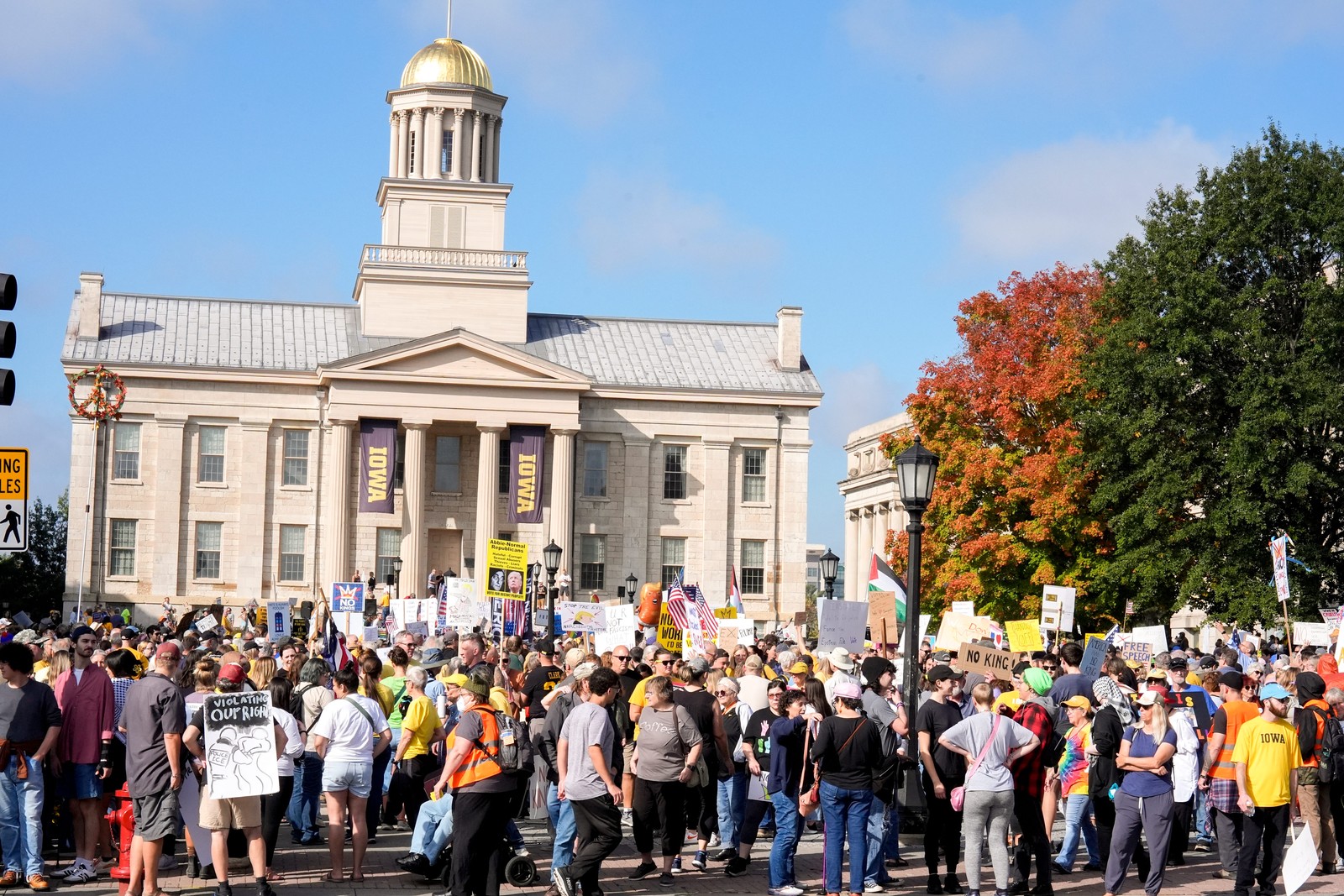 A group of protesters gathers in front of a building in Iowa City.