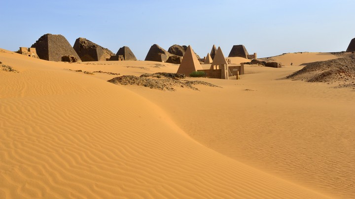 The ruins of several pyramids in the desert sands at Meroë, Sudan