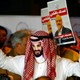 A demonstrator wearing a mask of Saudi Crown Prince Mohammed bin Salman attends a protest outside the Saudi consulate. In the background, other demonstrators hold signs with pictures of Jamal Khashoggi.