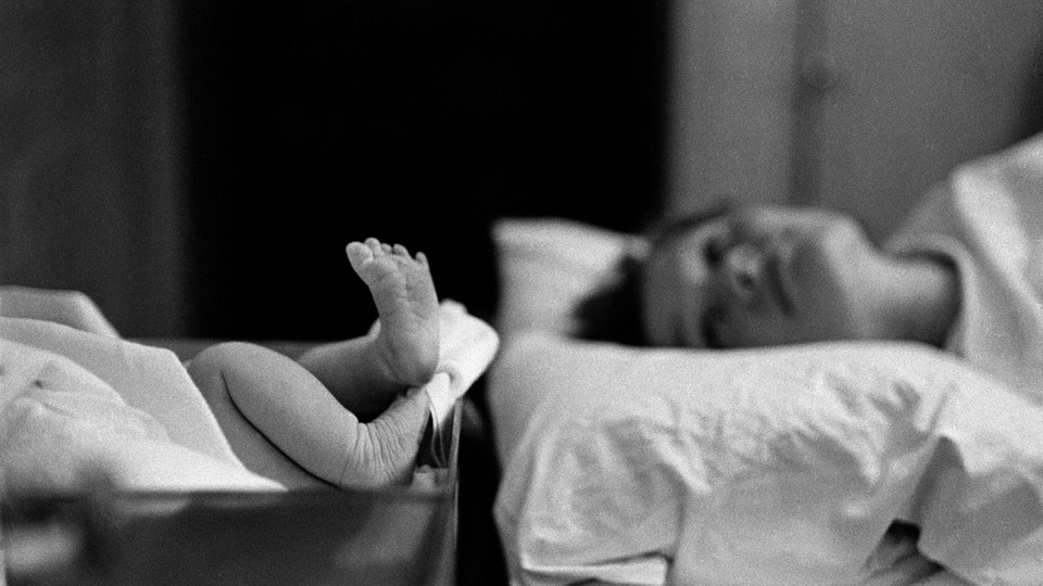 A mother looks at her newborn baby's feet