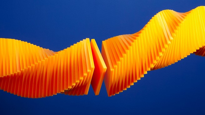 A spiraling orange shape made up of thin, square-shaped slices against a blue background