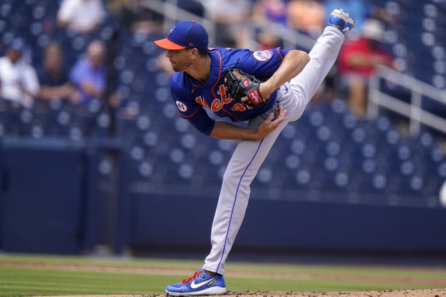 A baseball pitcher is photographed just after he releases a pitch.