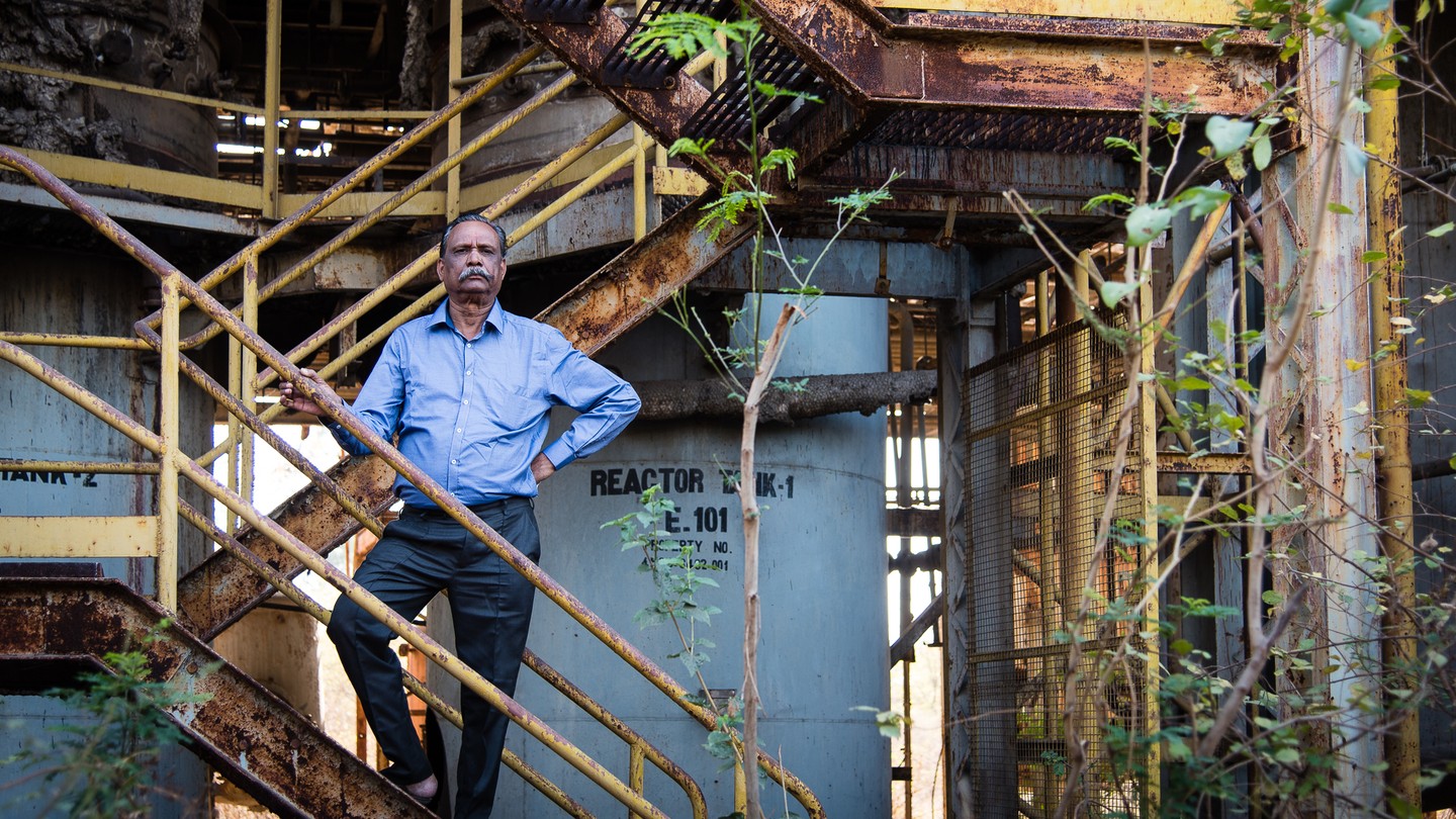 T. R. Chouhan stands on stairs at the ruins of the Union Carbide factory in Bhopal