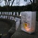 A woman lights a candle for someone who died by suicide.