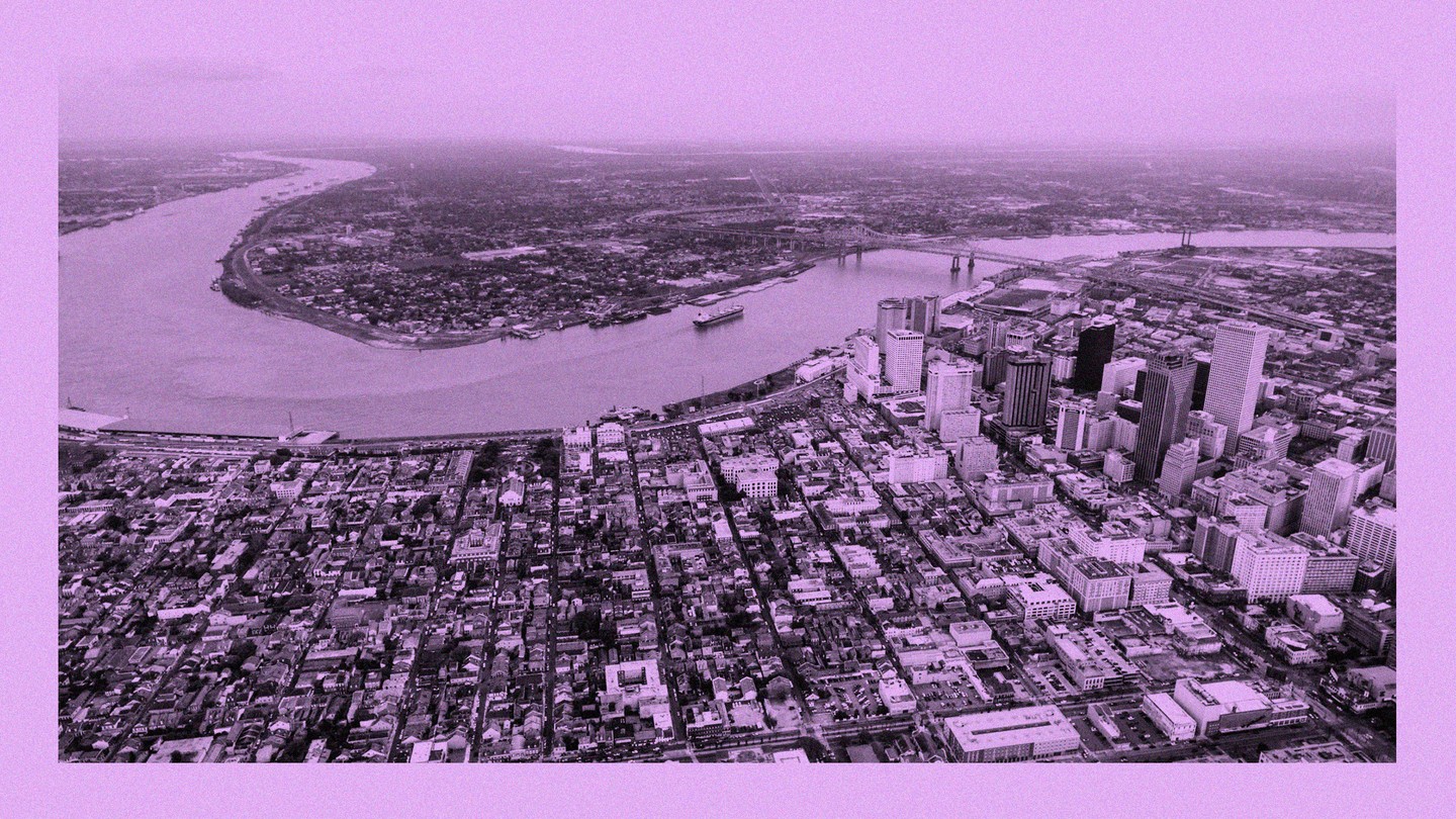A drone photo of downtown New Orleans and the Mississippi River, with the French Quarter in the foreground and the West Bank in the distance