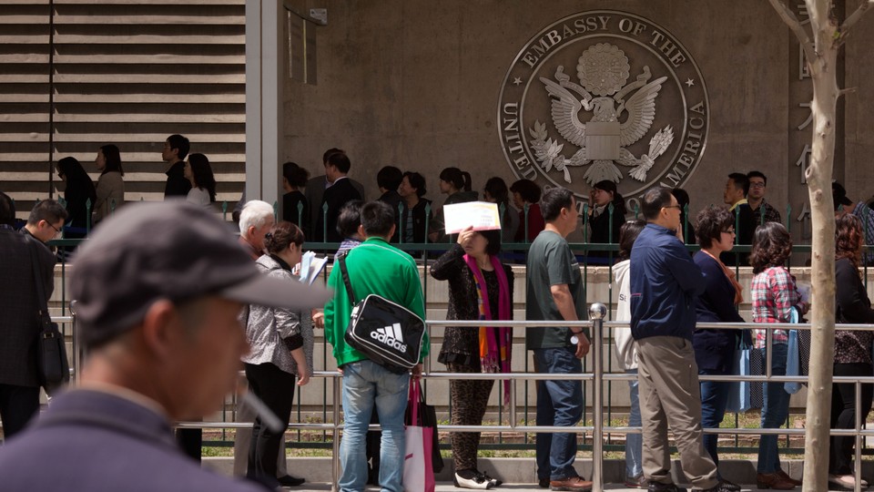 People wait in line outside the visa section of the U.S. embassy in Beijing in 2012.