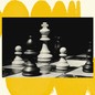 A black-and-white photograph is set on a cream-colored background. The background has a row of yellow circles at the top that look like they are curving away and a row of yellow circles at the bottom that look like they are curving in the other direction. The photo shows a chess board in black and white.