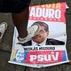 A foot stepping over a sign with Nicolás Maduro's face