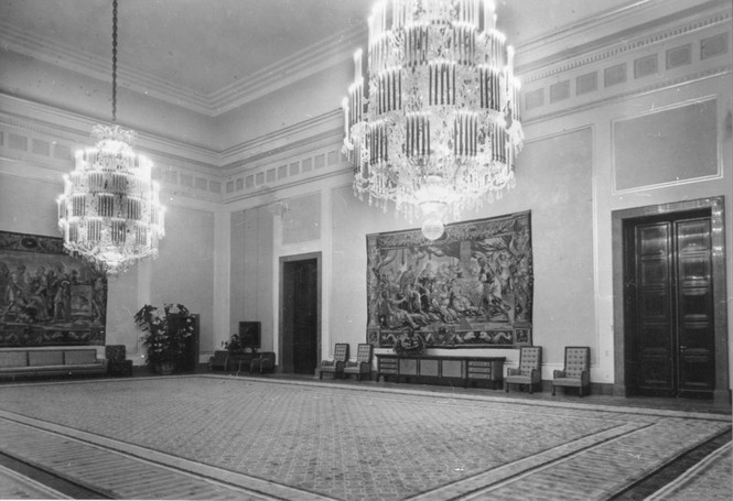 A reception room with large chandeliers and wall hangings