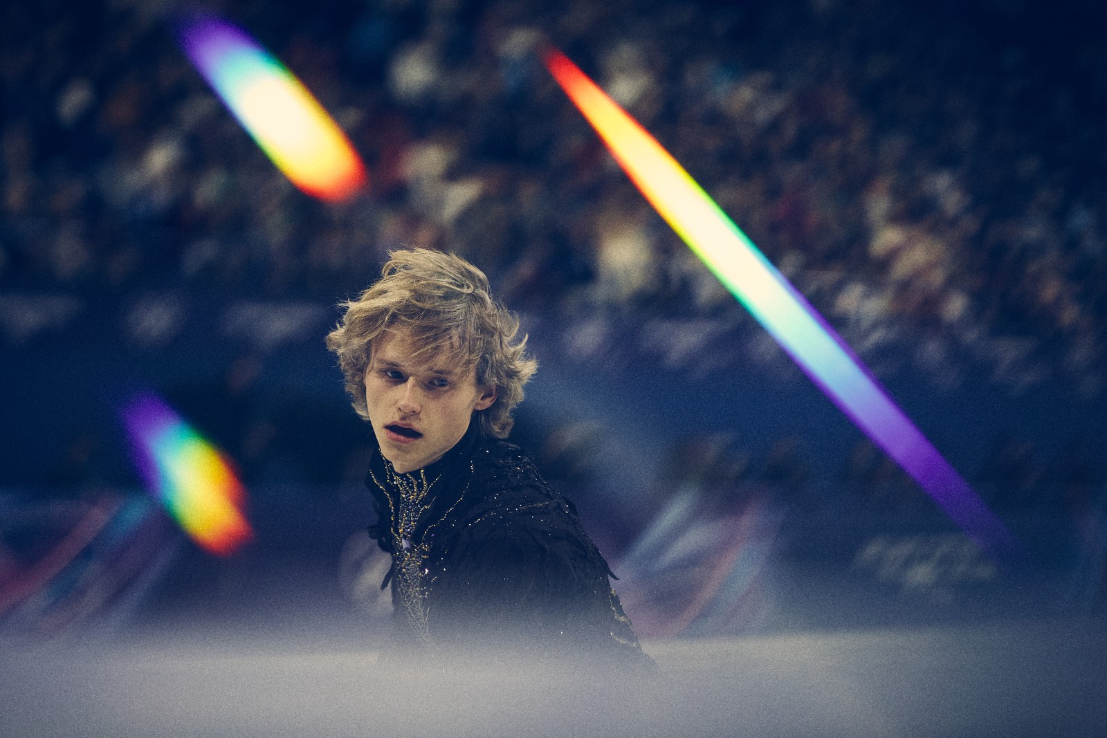 A figure skater, seen in a filtered image with several rainbow streaks