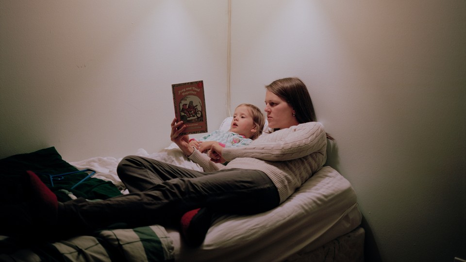 A mother reads 'Frog and Toad' with a toddler in bed