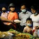A family wearing face masks buys food from a stall in Yangon, Myanmar.