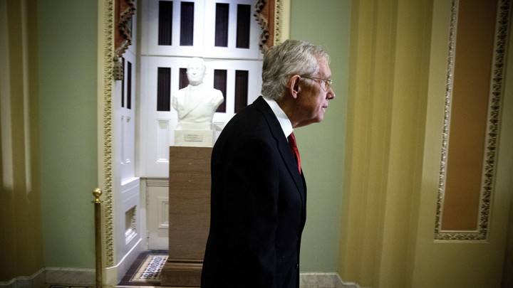 Former Senate Majority Leader Harry Reid walks in a hallway in the Capitol.
