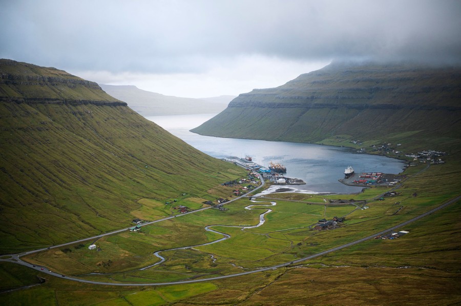 Houses and docks line a narrow fjord.